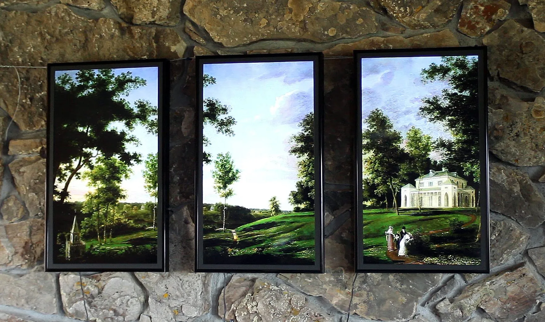 Three portrait frames side by side on a rough stone wall, together showing one landscape painting of a park with a white villa